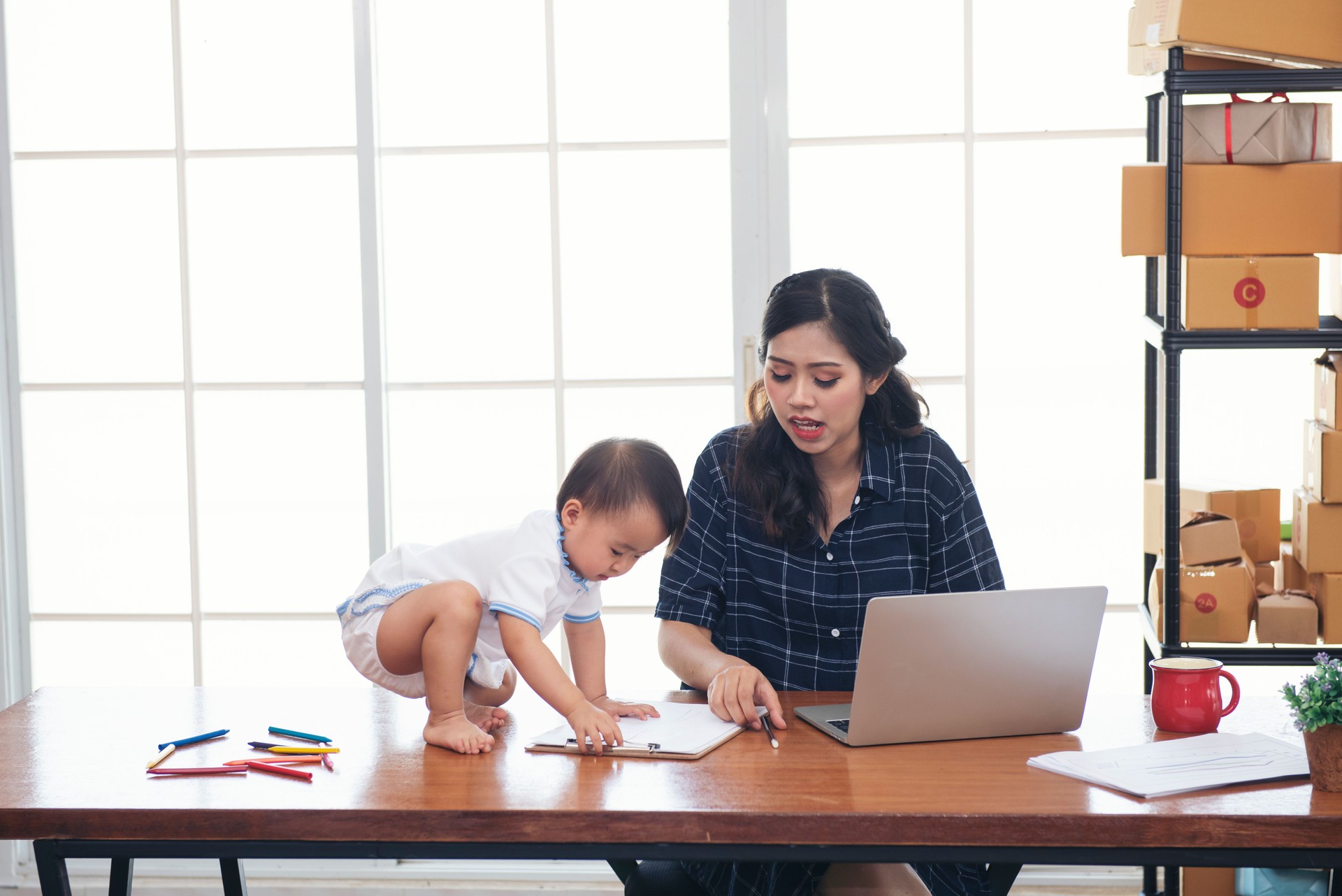 working asia mother baby kid and laptop computer at home office.